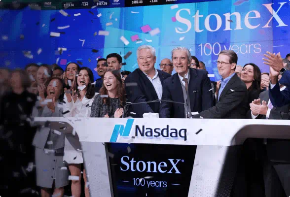 StoneX employees celebrate the company's 100th anniversary at Nasdaq, with Sean O'Connor and John Radziwill at the front.